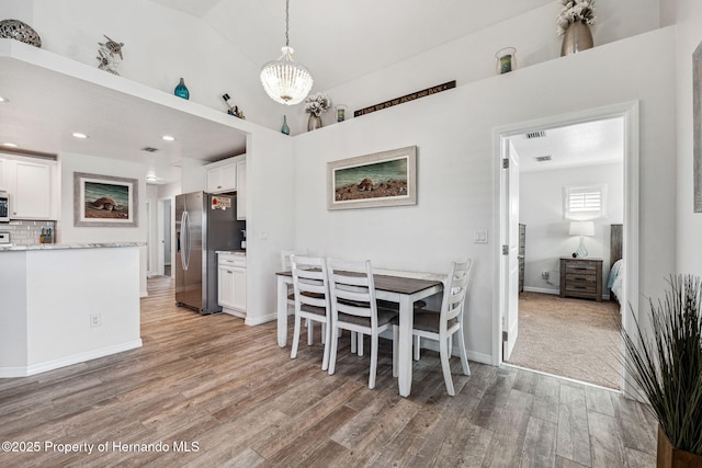 dining space with wood-type flooring and lofted ceiling