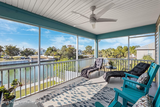 sunroom featuring a water view and ceiling fan