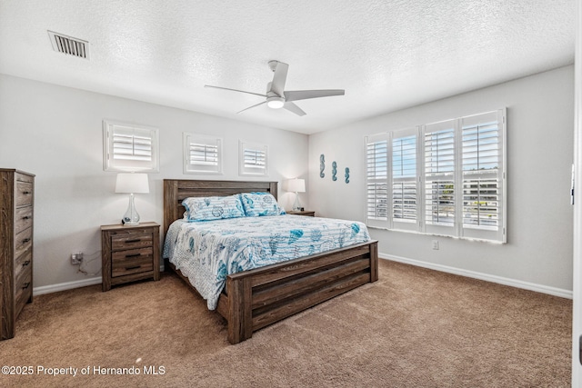 carpeted bedroom featuring ceiling fan and a textured ceiling