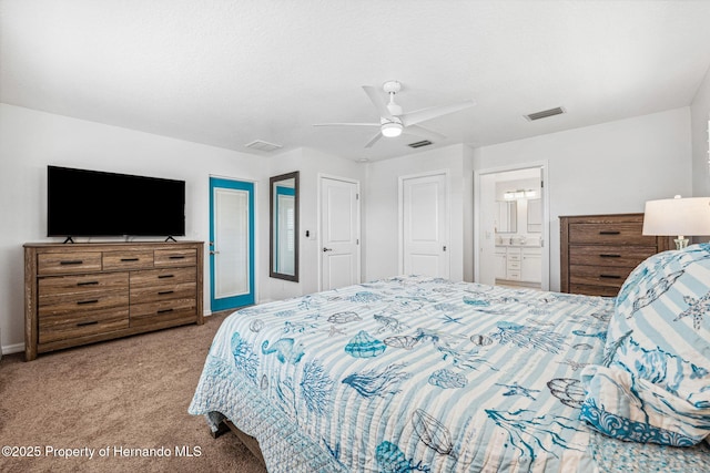 carpeted bedroom featuring ceiling fan and ensuite bath