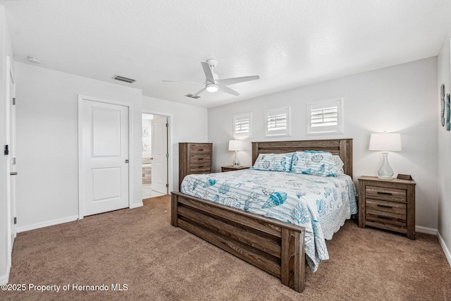 carpeted bedroom featuring ceiling fan, a textured ceiling, and ensuite bath