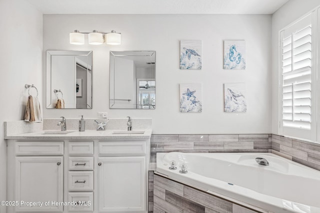 bathroom with vanity and tiled bath