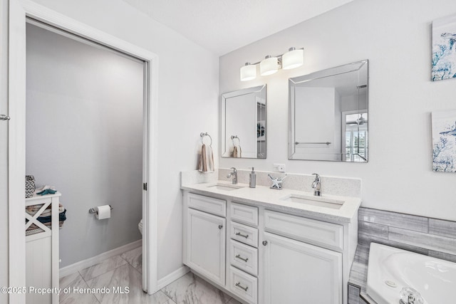 bathroom featuring vanity, toilet, and a tub