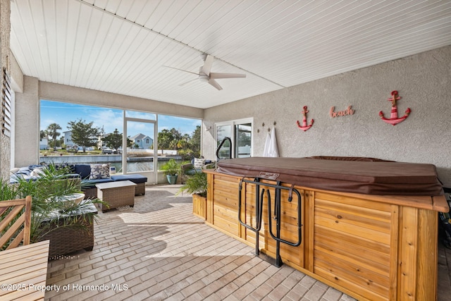 sunroom featuring a water view and ceiling fan