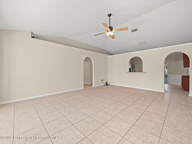 tiled spare room with ceiling fan, a textured ceiling, and vaulted ceiling