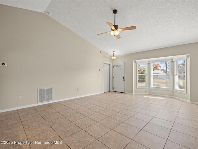 empty room featuring ceiling fan, light tile patterned floors, and vaulted ceiling