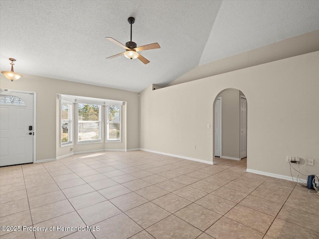 interior space with a textured ceiling, ceiling fan, light tile patterned flooring, and lofted ceiling