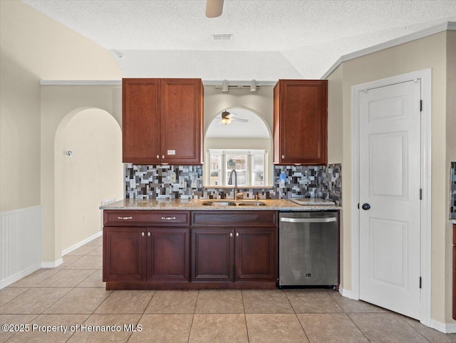 kitchen with sink, a textured ceiling, stainless steel dishwasher, and lofted ceiling