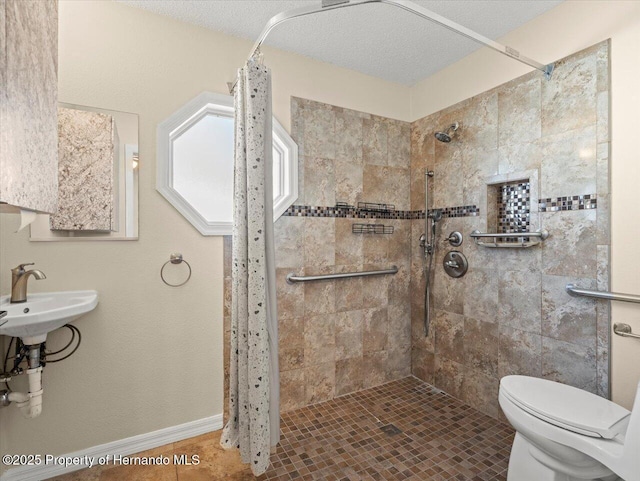 bathroom featuring a textured ceiling, tile patterned floors, sink, toilet, and a shower with shower curtain