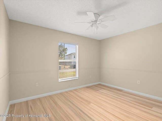 spare room with ceiling fan, light wood-type flooring, and a textured ceiling