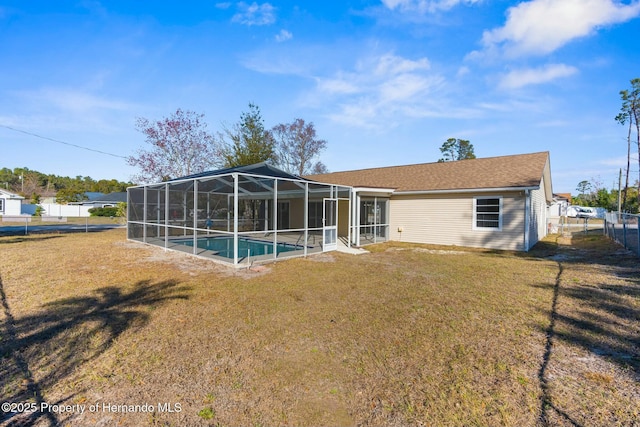 rear view of property with a lanai and a yard