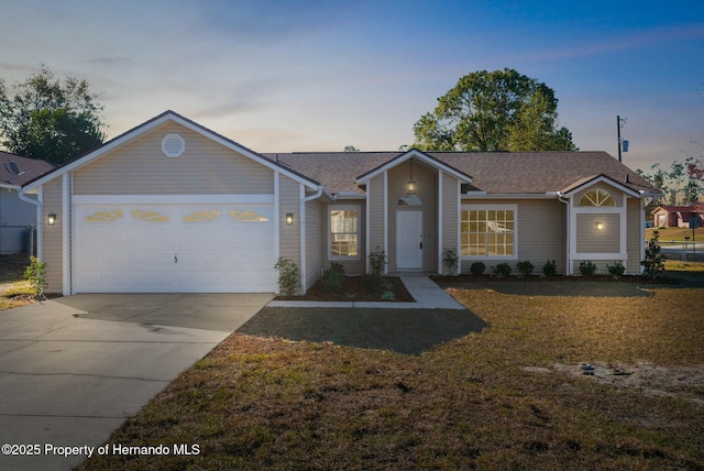 single story home with a garage and a yard