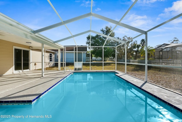 view of swimming pool featuring glass enclosure and a patio area