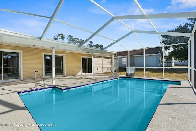 view of swimming pool with glass enclosure and a patio area