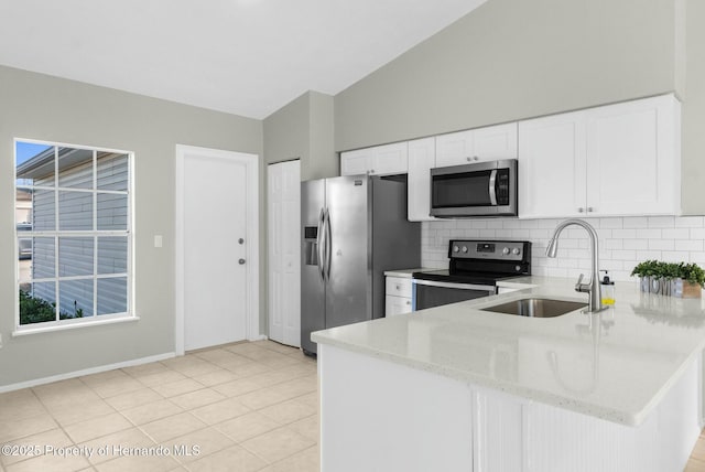 kitchen with light stone countertops, sink, white cabinetry, and appliances with stainless steel finishes