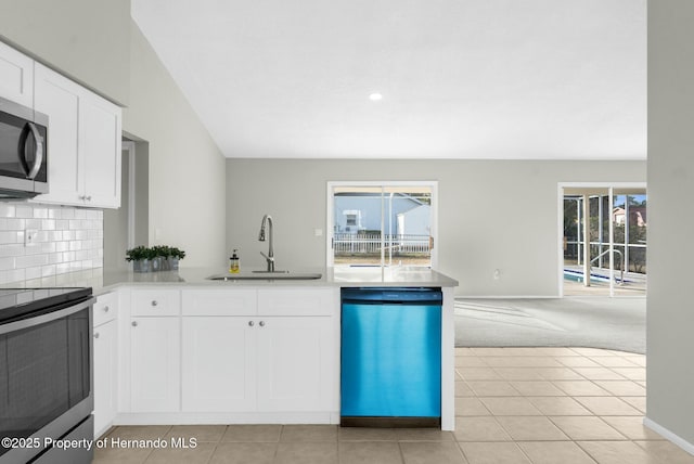 kitchen featuring white cabinets, appliances with stainless steel finishes, light carpet, tasteful backsplash, and sink