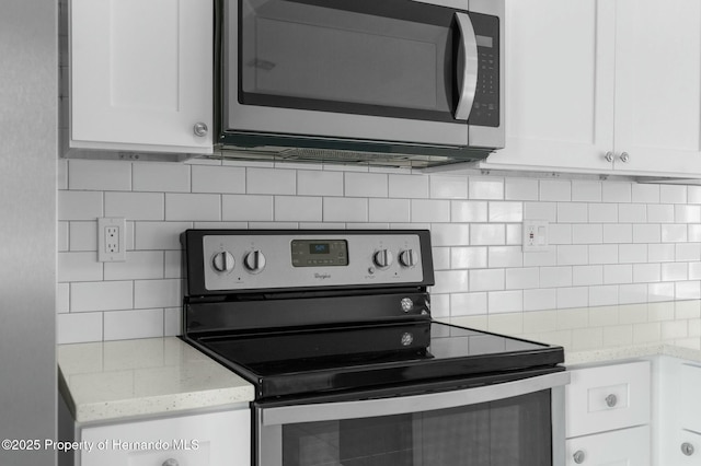 kitchen featuring white cabinets, decorative backsplash, appliances with stainless steel finishes, and light stone counters