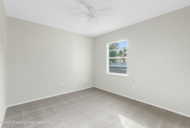 carpeted spare room with ceiling fan