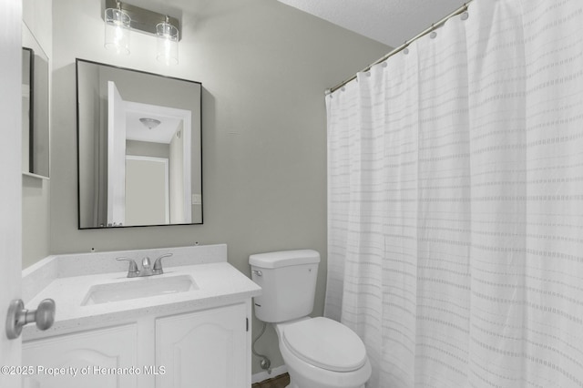 bathroom featuring toilet, vanity, a shower with curtain, and a textured ceiling