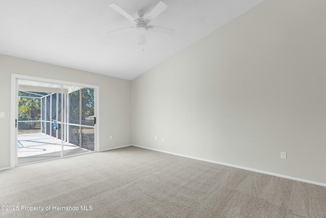 carpeted spare room with ceiling fan and vaulted ceiling