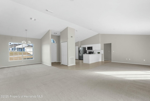 unfurnished living room featuring light carpet, an inviting chandelier, and high vaulted ceiling