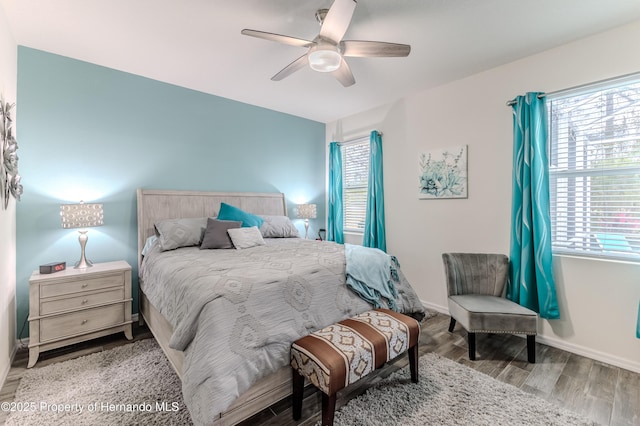 bedroom featuring multiple windows, wood-type flooring, and ceiling fan