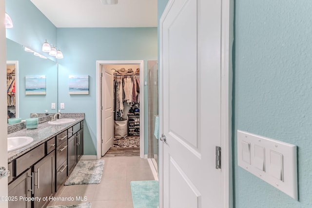 bathroom with walk in shower, vanity, and tile patterned flooring