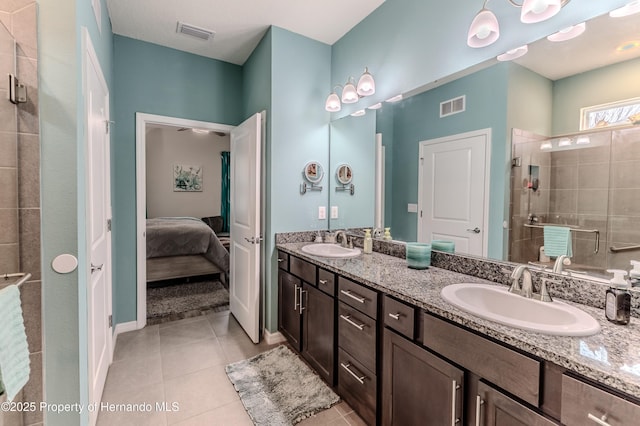 bathroom with walk in shower, vanity, and tile patterned flooring