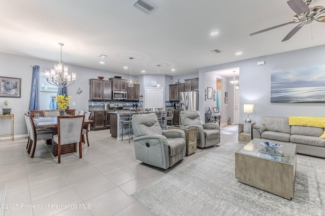 living room featuring light tile patterned floors and ceiling fan with notable chandelier