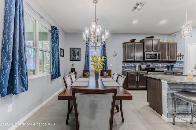 dining room with a notable chandelier, sink, and light tile patterned floors