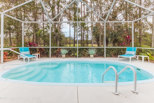 view of swimming pool with a lanai and a patio