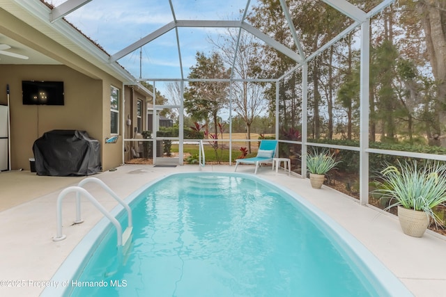 view of swimming pool with area for grilling, a patio area, and glass enclosure