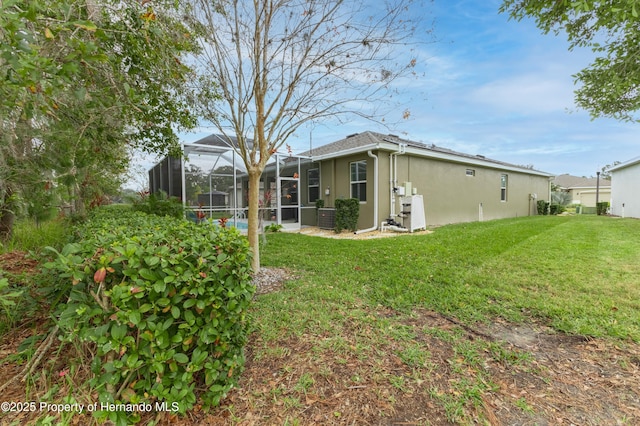 rear view of house with a lanai and a lawn