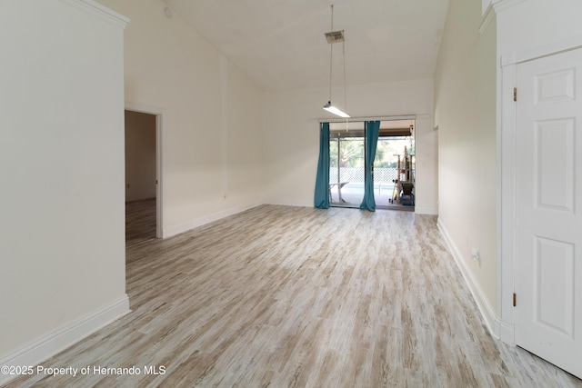 spare room featuring light hardwood / wood-style flooring and a high ceiling