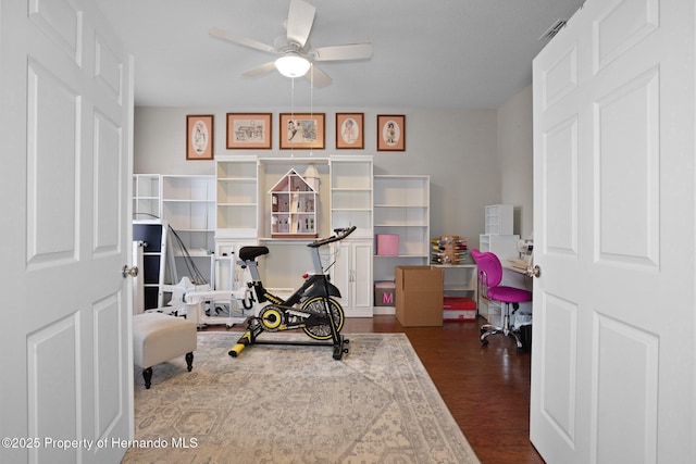 workout room with dark wood-type flooring and ceiling fan