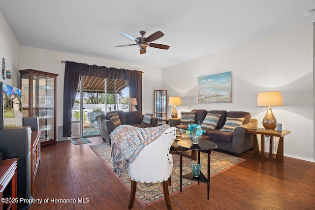 living room with dark hardwood / wood-style flooring and ceiling fan