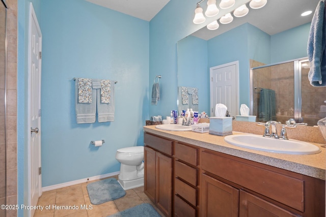 bathroom featuring vanity, toilet, tile patterned flooring, and a shower with door