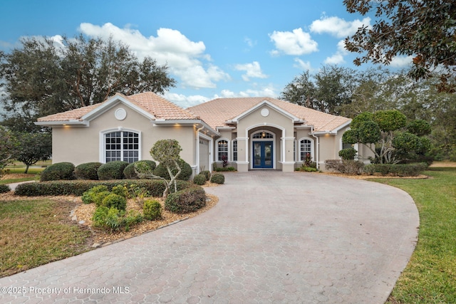 view of front of home with a garage and french doors