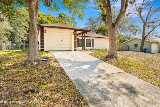 view of front of home with a garage, fence, concrete driveway, and stucco siding