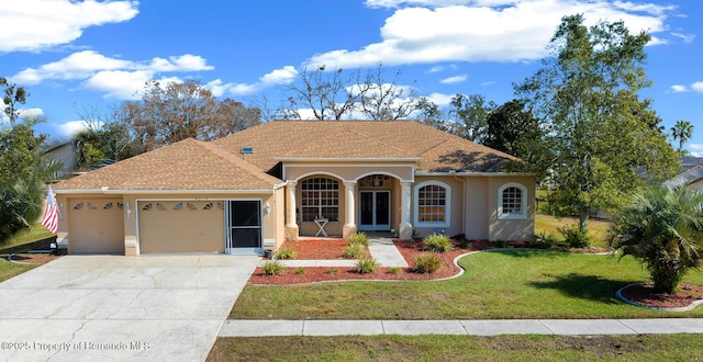 view of front of property with an attached garage, a front lawn, concrete driveway, and stucco siding