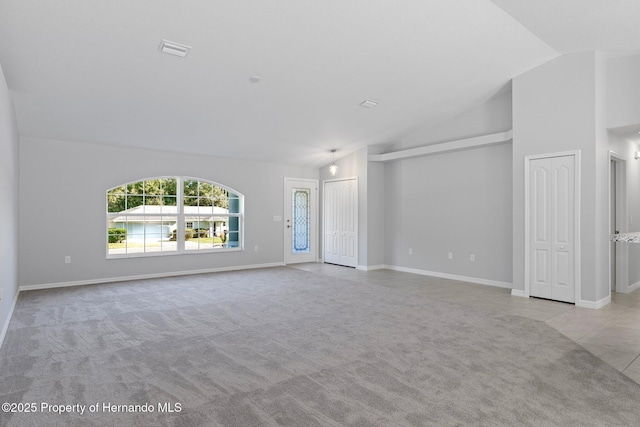 unfurnished living room with light colored carpet and lofted ceiling