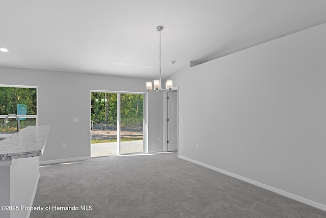 carpeted empty room featuring sink, a chandelier, and lofted ceiling