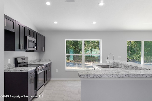 kitchen featuring sink, stainless steel appliances, light tile patterned floors, and plenty of natural light