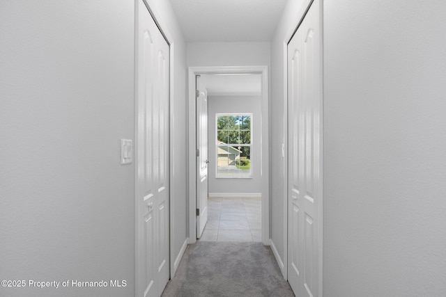 hall with light colored carpet