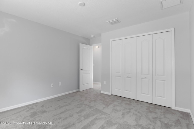 unfurnished bedroom featuring a closet and light carpet