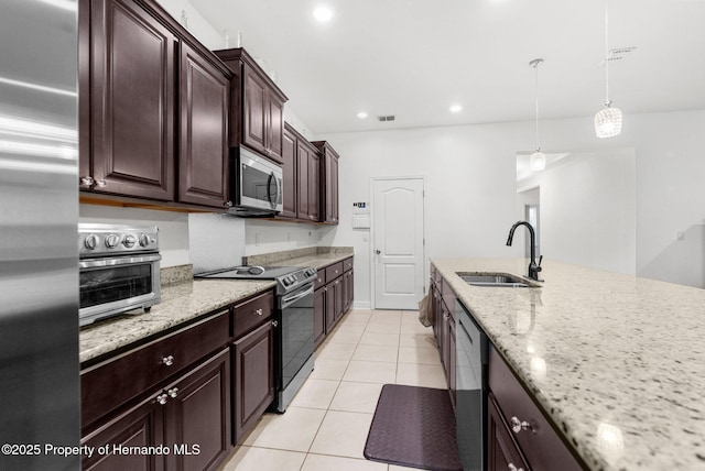 kitchen with light tile patterned flooring, decorative light fixtures, sink, light stone counters, and stainless steel appliances