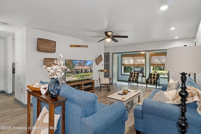 living room featuring light hardwood / wood-style flooring and ceiling fan