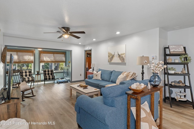 living room with ceiling fan and light hardwood / wood-style flooring