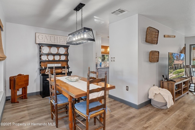 dining area with sink and light hardwood / wood-style flooring