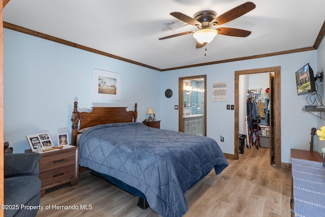 bedroom with connected bathroom, a closet, a walk in closet, ceiling fan, and light hardwood / wood-style flooring